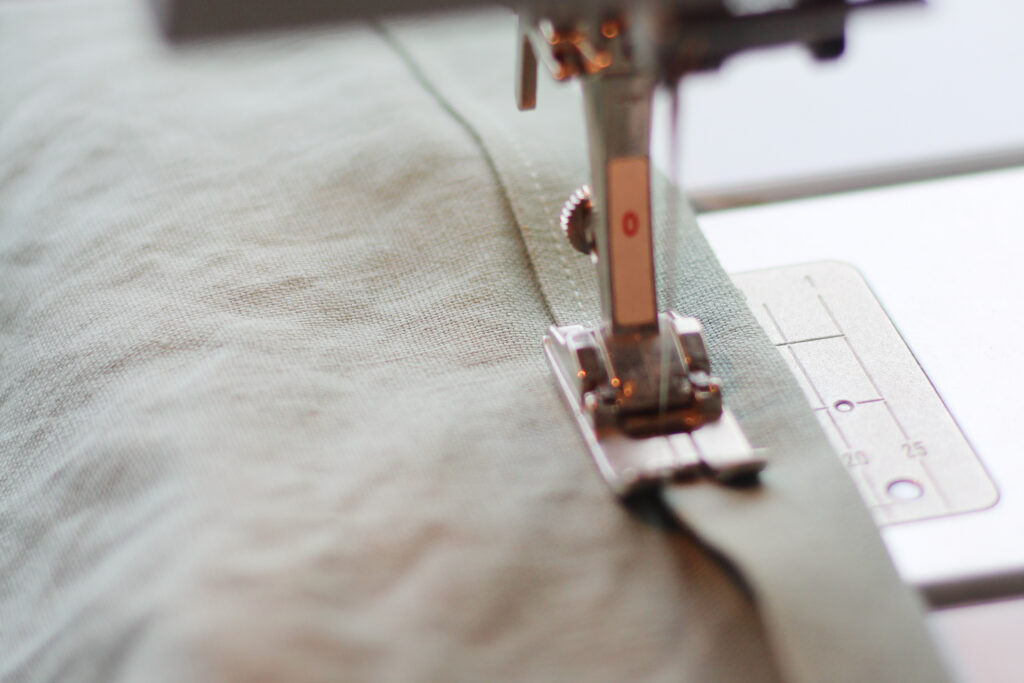 sewing machine foot sewing a hem
