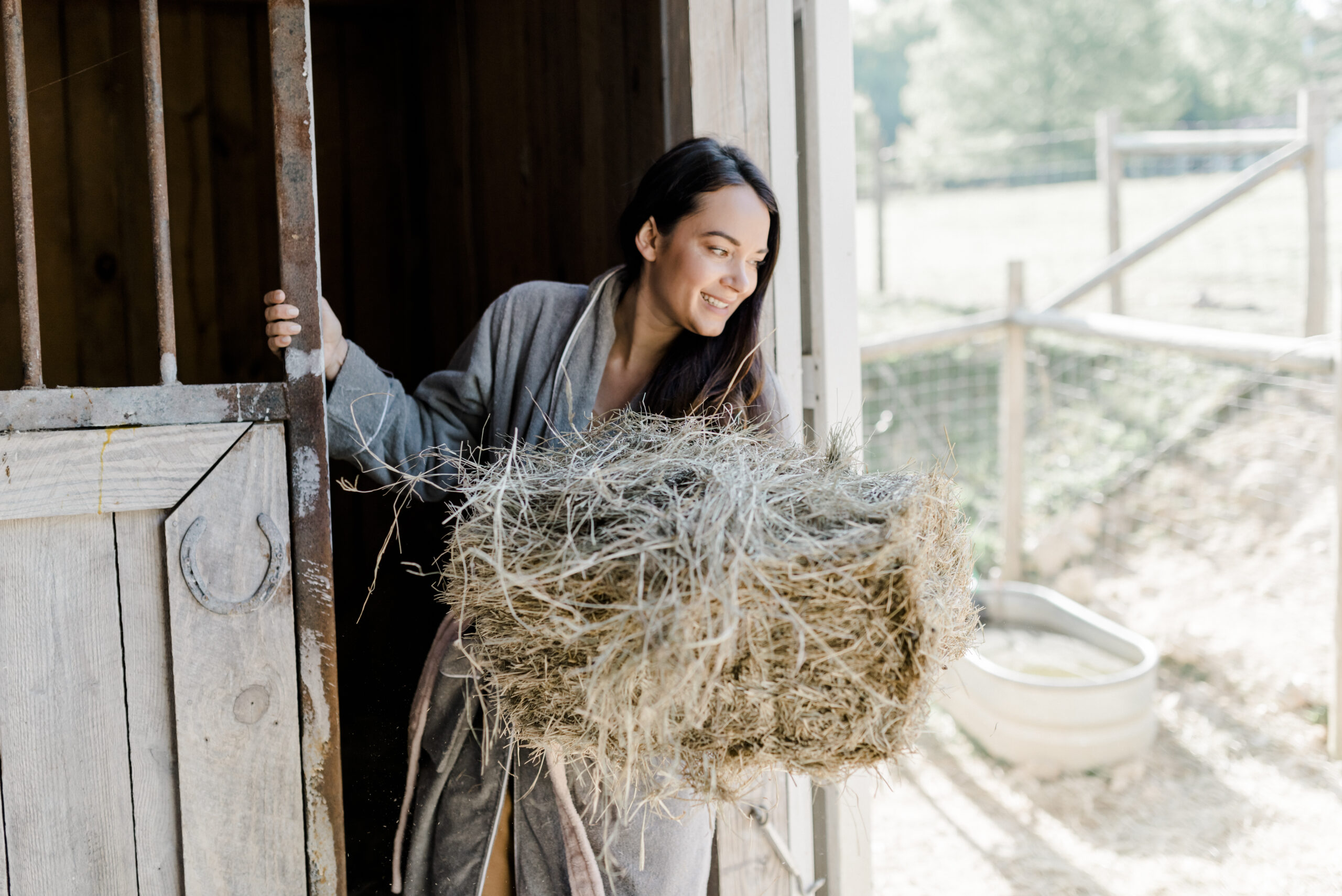 a woman holding slabs of hay wearing a robe
