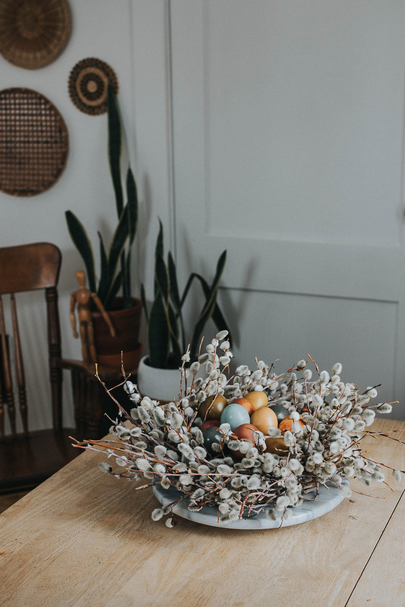 Spring Centrepiece With Naturally Dyed Eggs & Pussy Willow Nest sitting on a table