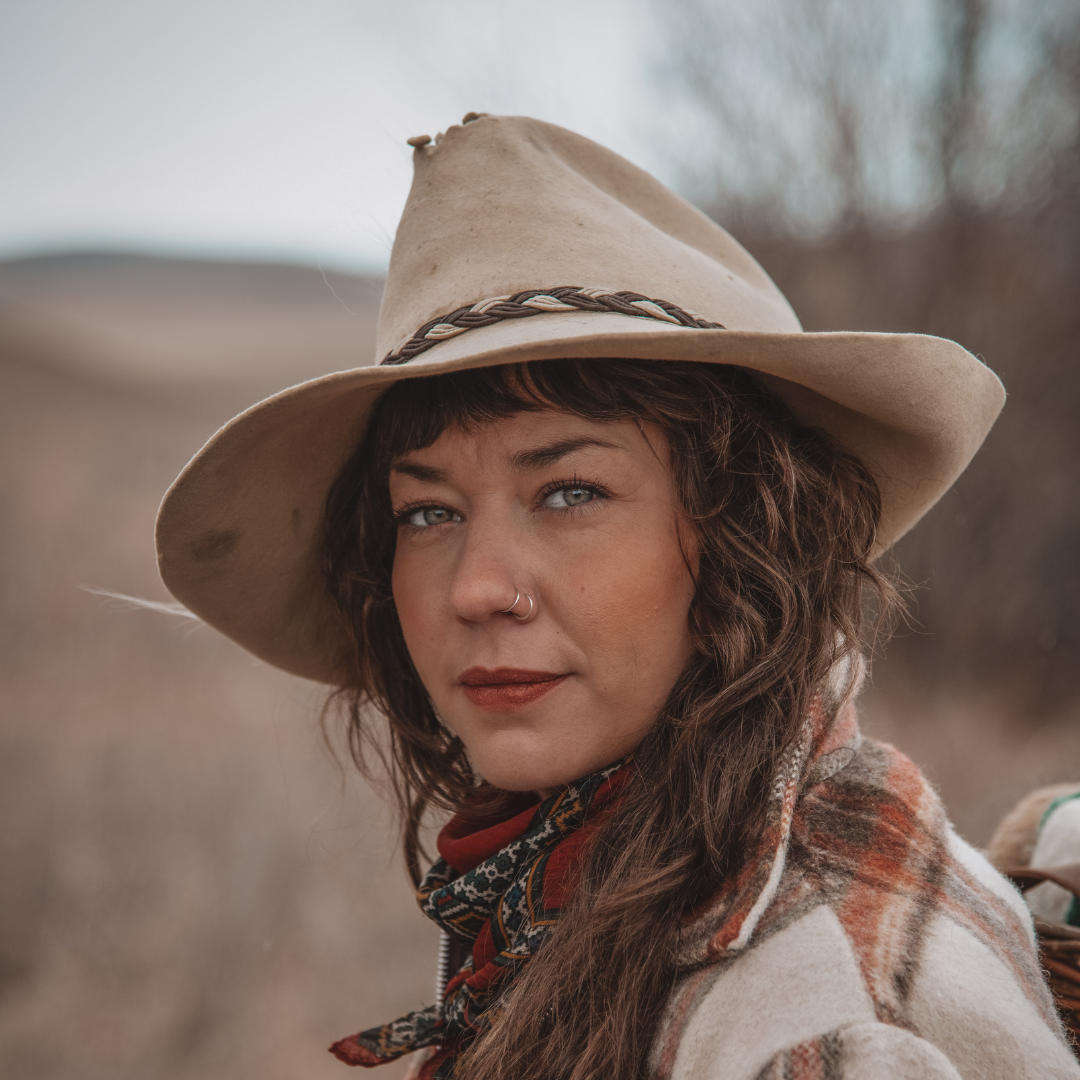 Alyse looks at the camera wearing a tan coloured hat and a plaid jacket